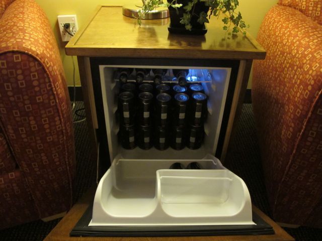 A small fridge filled with bottles of beer