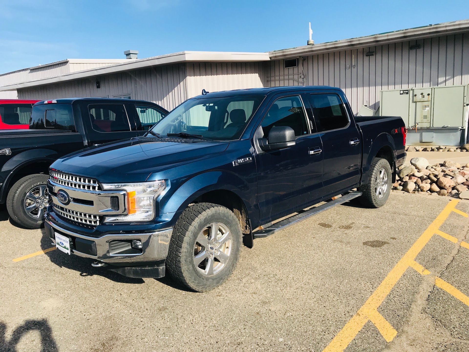 A dark blue Ford F-150 pickup truck parked in an outdoor lot on a sunny day. | Aurora Automotive
