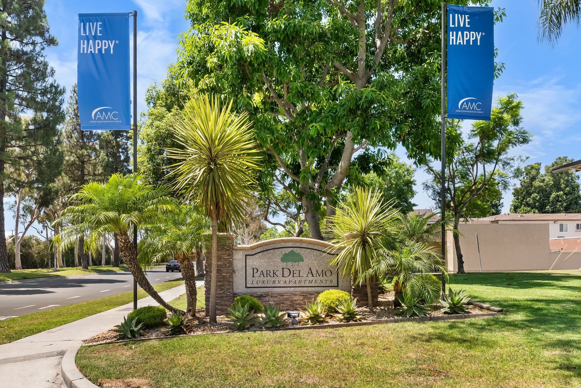 monument sign and two Live Happy flags