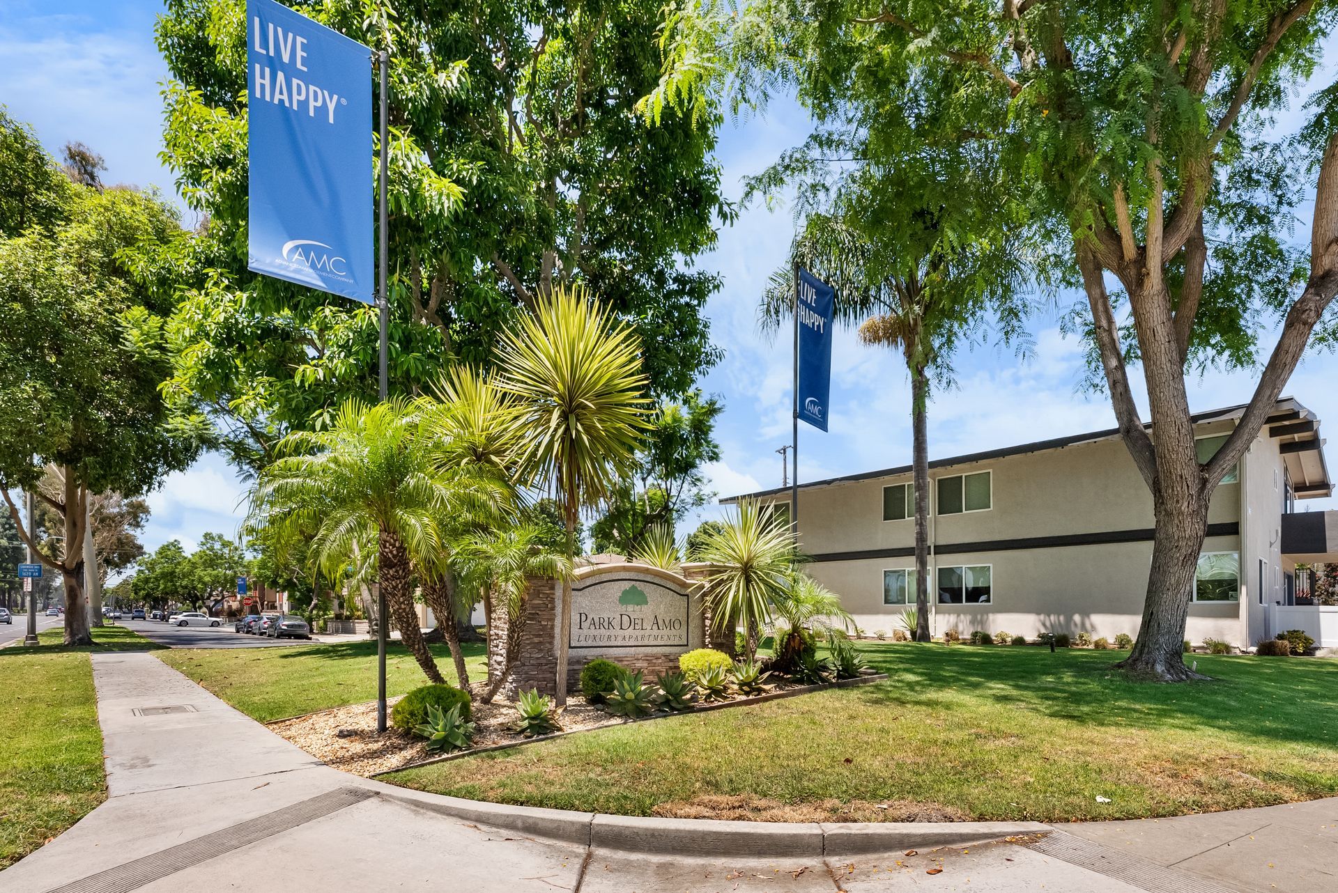 front monument sign and two Live Happy flags
