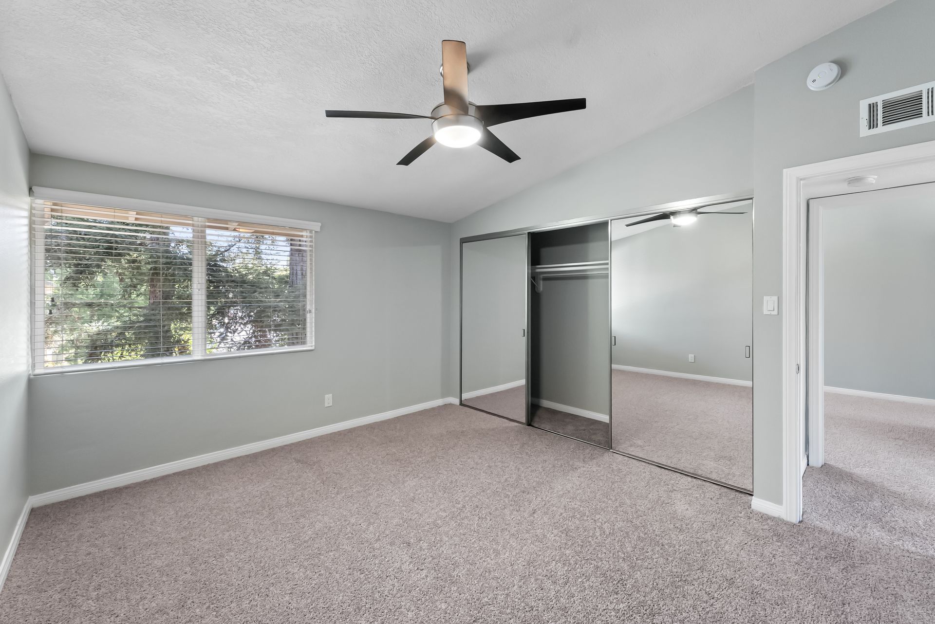 bedroom with mirrored closet and ceiling fan