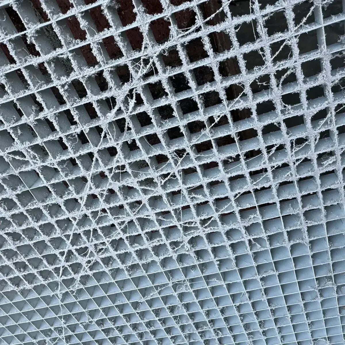 A close up of a metal grate with holes in it.