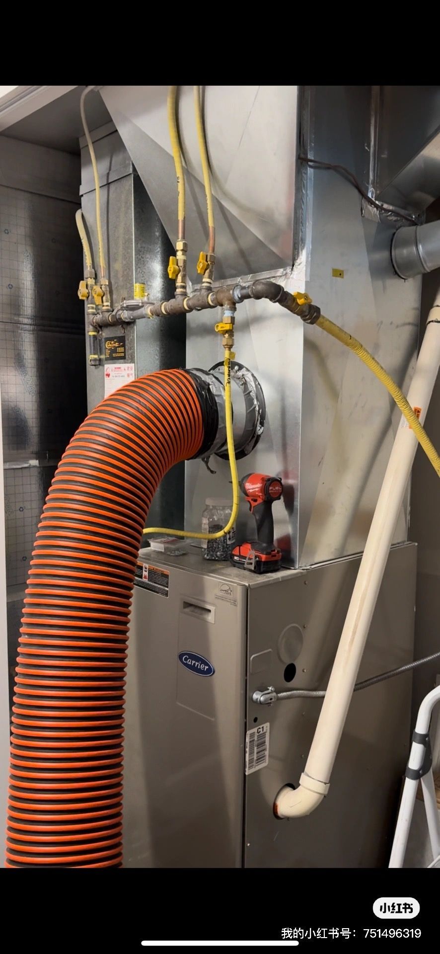 A hose is coming out of a furnace with a drill attached to it.