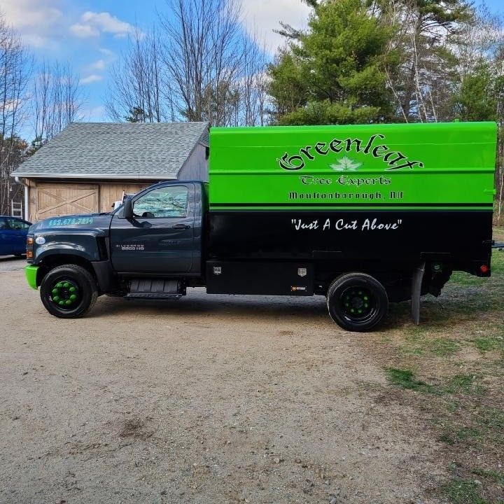 A green and black truck with the word greenleaf on it