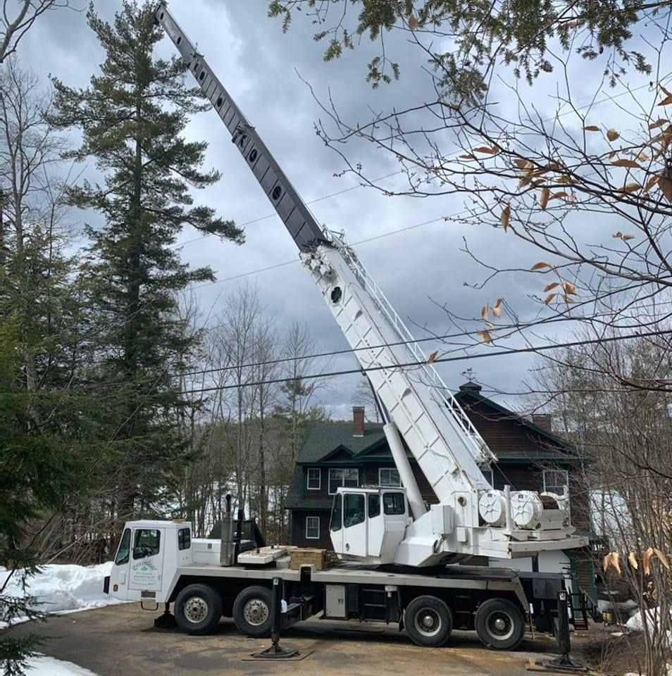 A large white crane is parked in front of a house