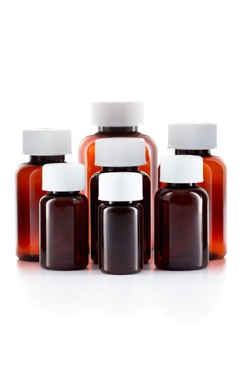 a group of brown plastic bottles with white lids on a white background .