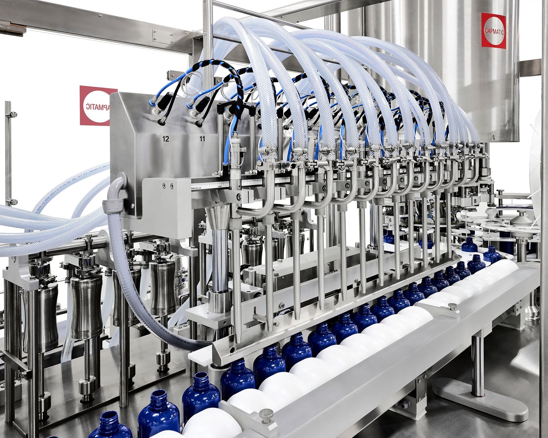 a machine is filling bottles with liquid in a factory .