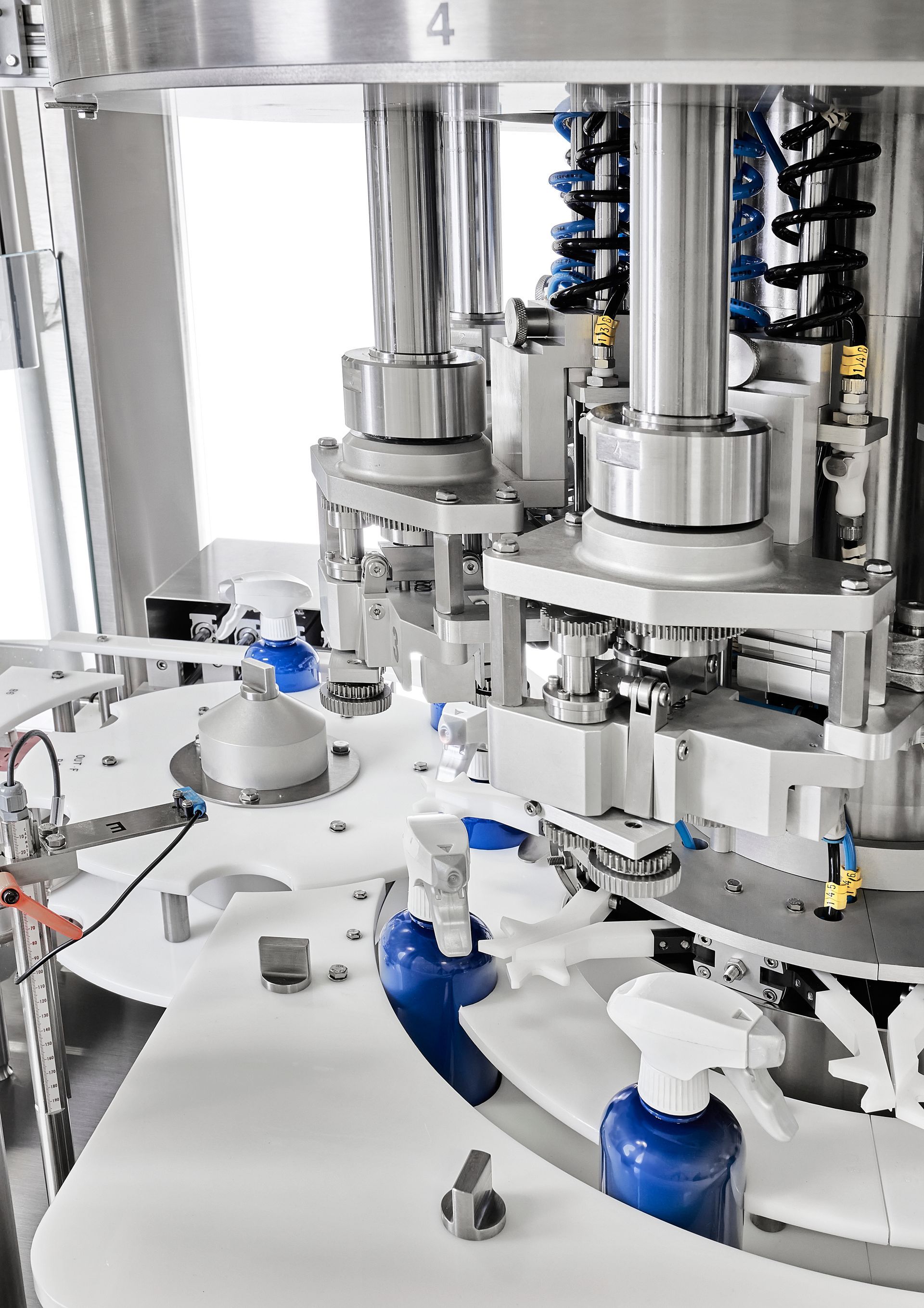 a machine is making bottles of soap in a factory .