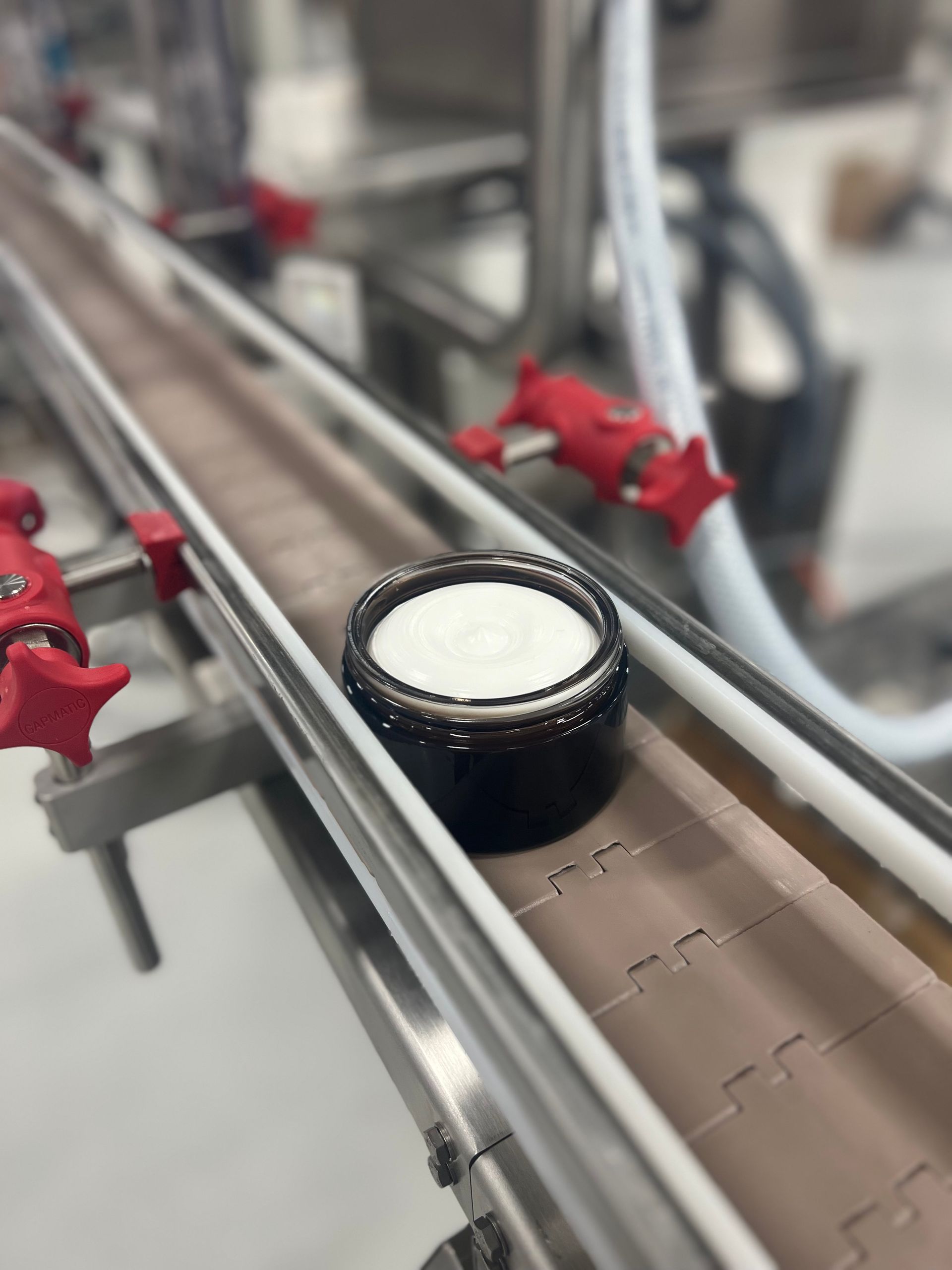 a bowl of cream is on a conveyor belt in a factory .