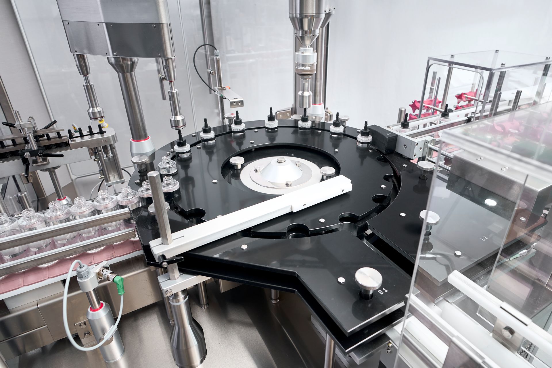a machine is moving bottles on a conveyor belt in a factory .