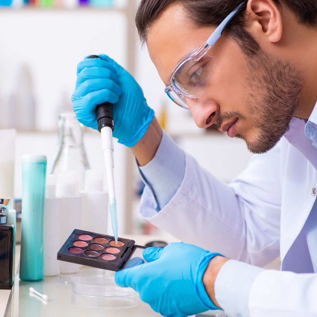 a man wearing blue gloves is using a pipette to apply makeup