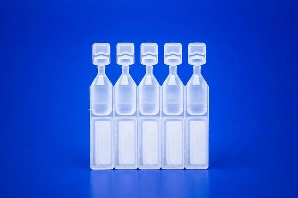 a row of plastic bottles filled with liquid on a blue background .