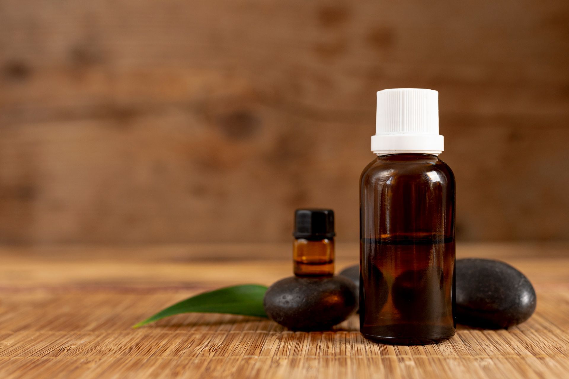 two bottles of essential oil are sitting on a wooden table .