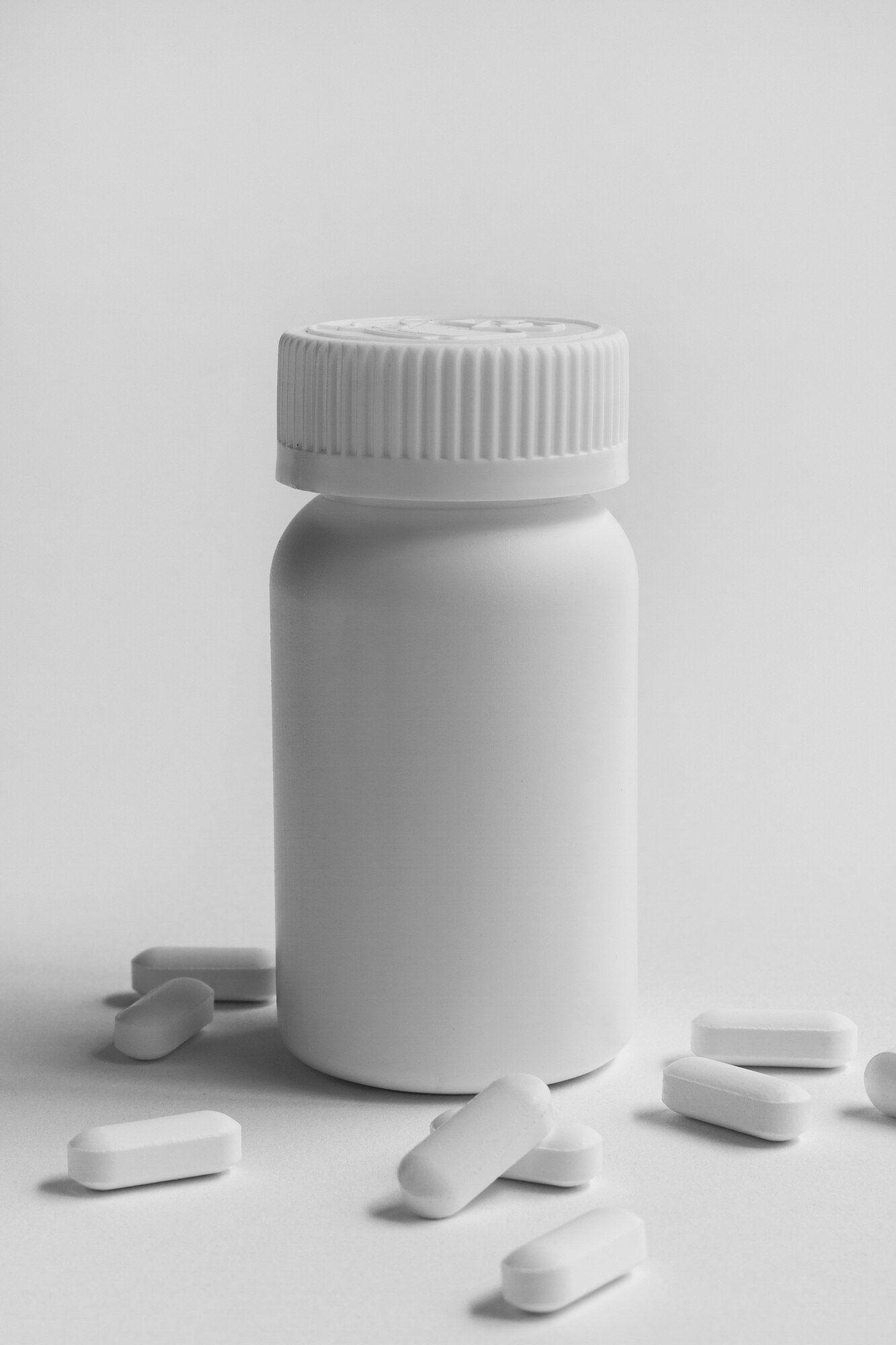 a white bottle filled with pills on a white surface .