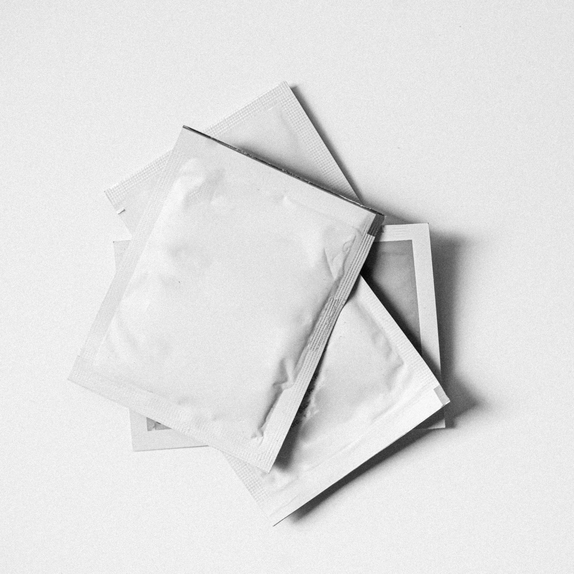 three white envelopes are stacked on top of each other on a white surface .