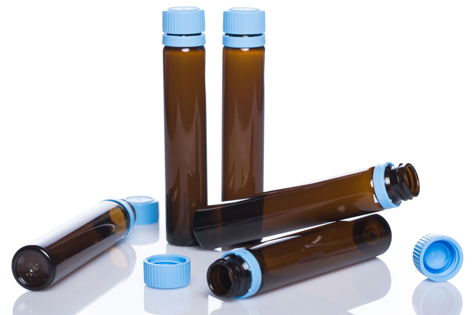 a group of brown bottles with blue caps on a white surface