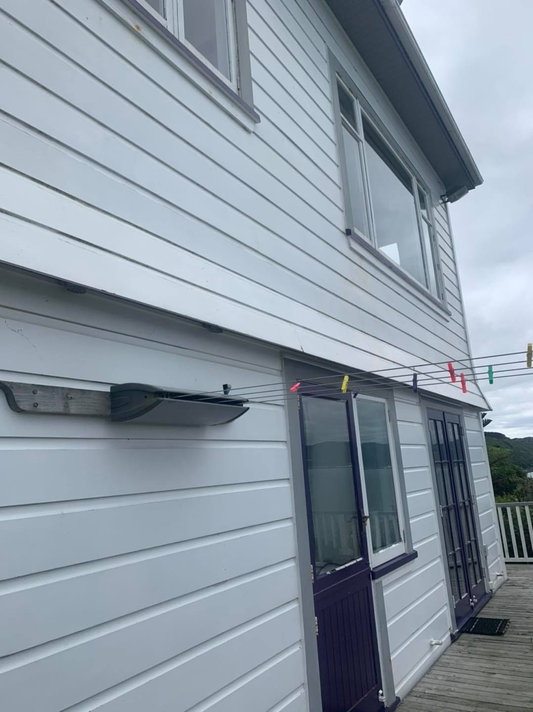 A white house with a purple door and windows.