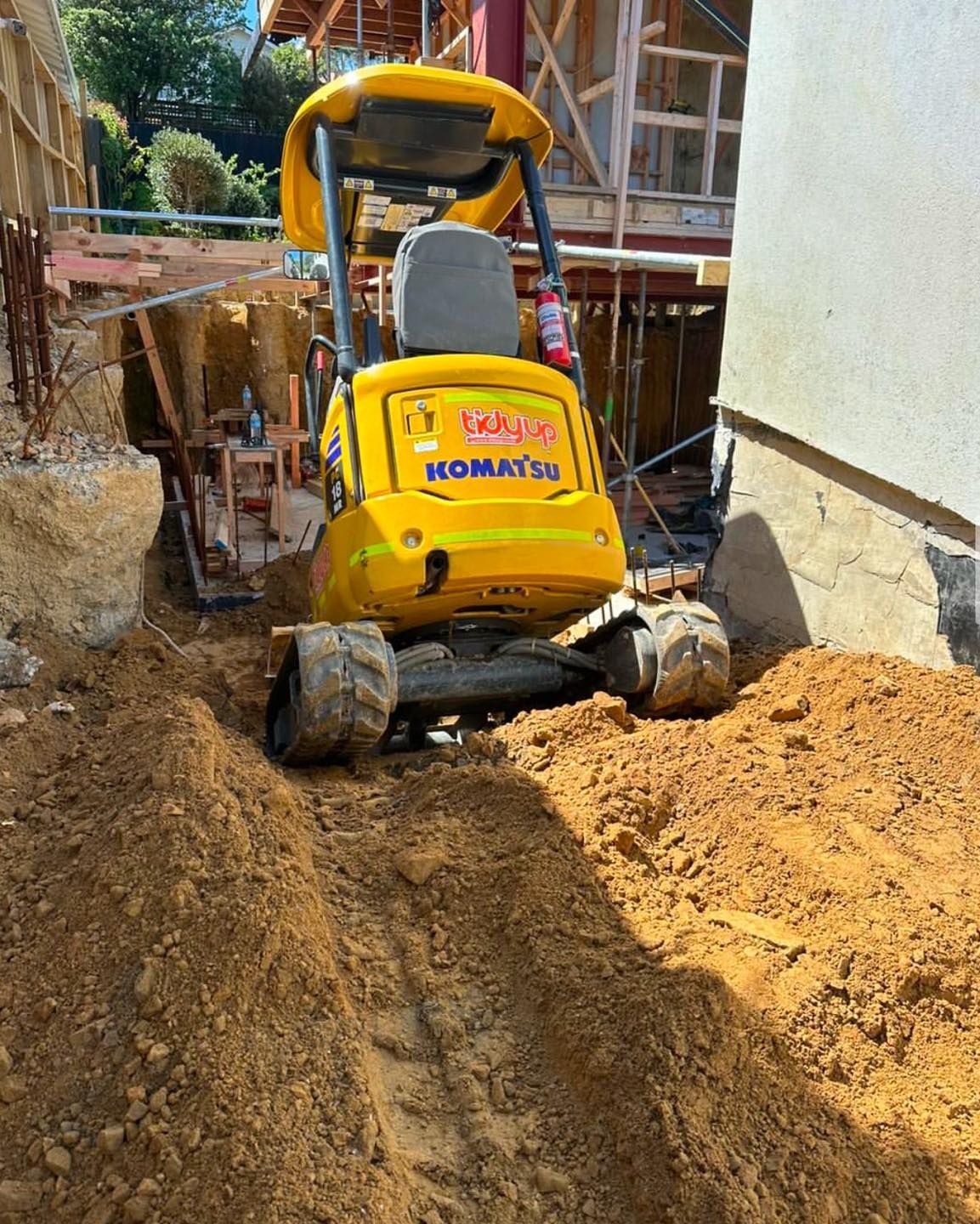 A yellow excavator is digging a hole in the dirt.