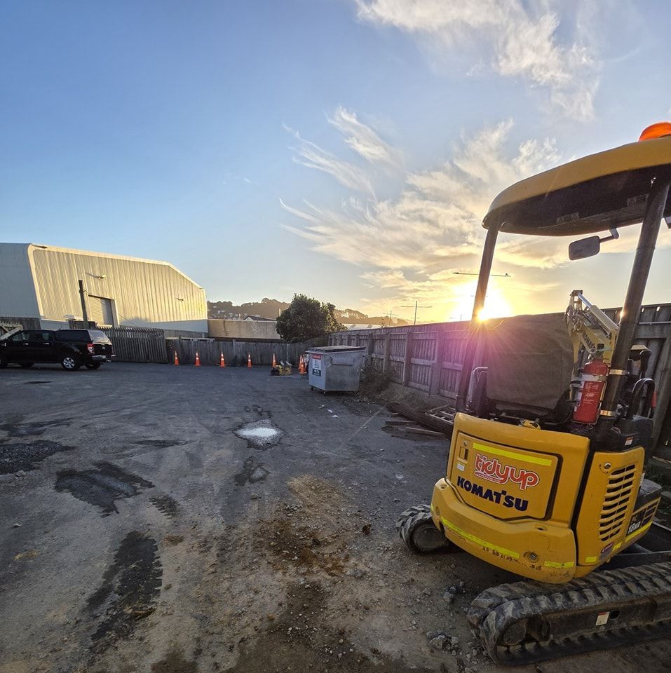A yellow komatsu excavator is parked in a parking lot