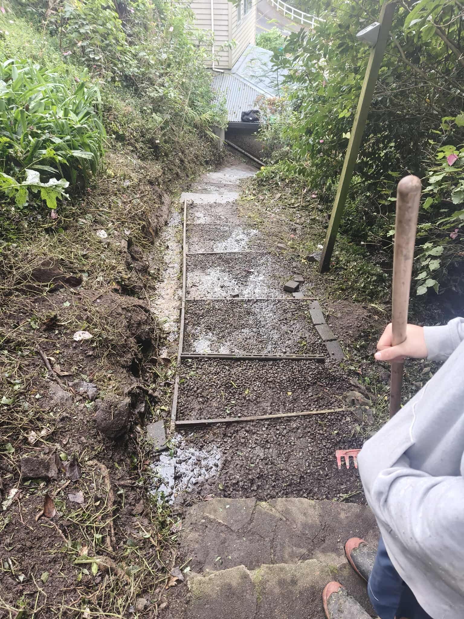 A person is holding a shovel next to a set of stairs.