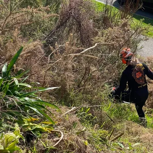 A man is cutting grass with a lawn mower in a field.