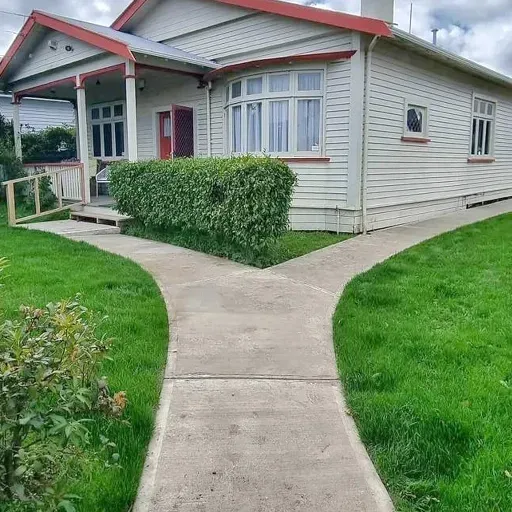 A house with a concrete walkway leading to it