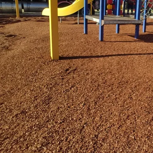 A playground with a yellow slide and blue stairs