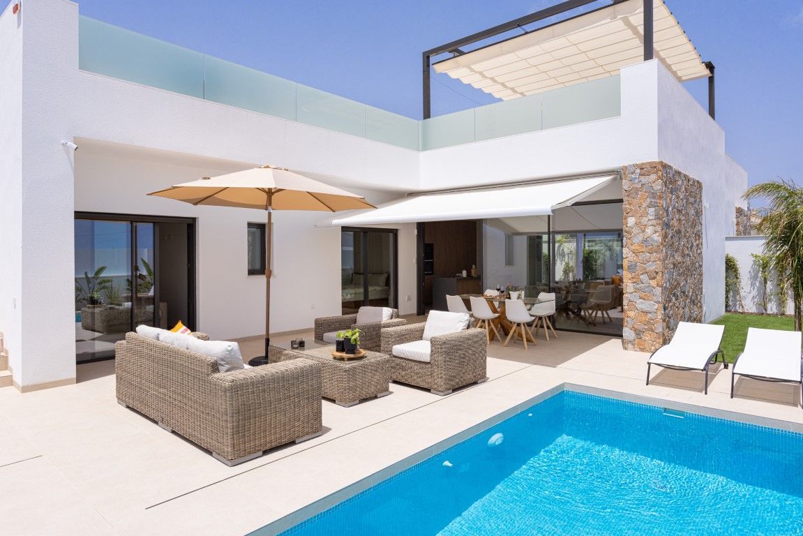 There is a large swimming pool in front of a house.