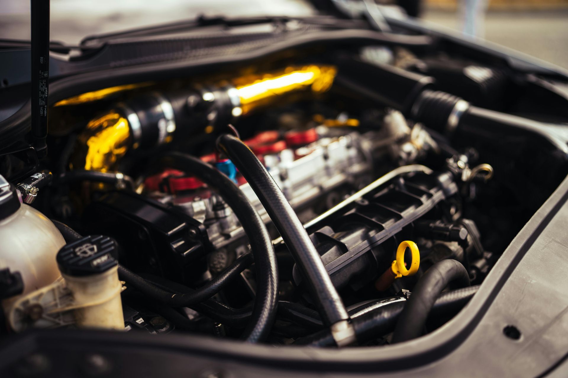A close up of a car engine with the hood open.
