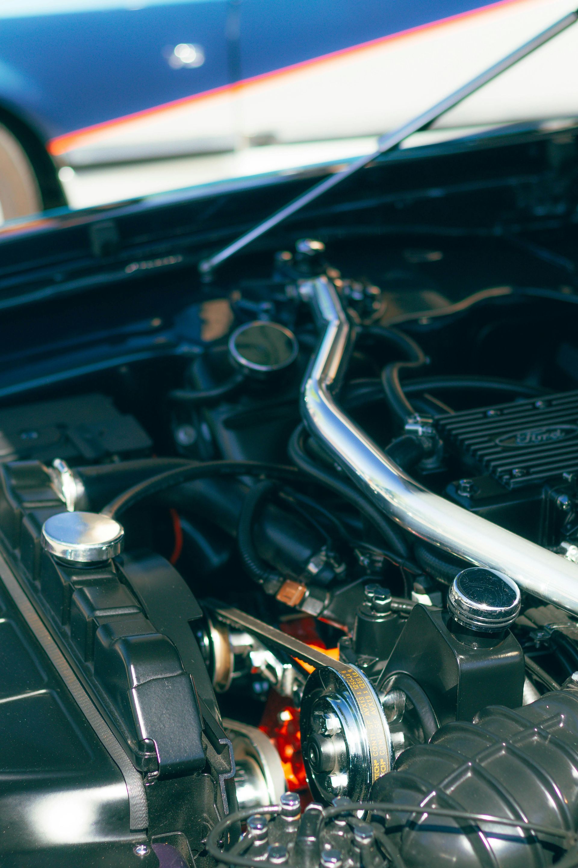 A close up of a car engine with the hood open