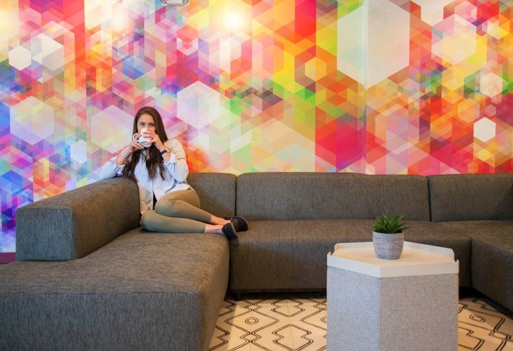 a woman is sitting on a couch in a living room drinking coffee .