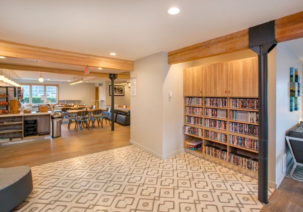 a large room with a lot of bookshelves and a rug .