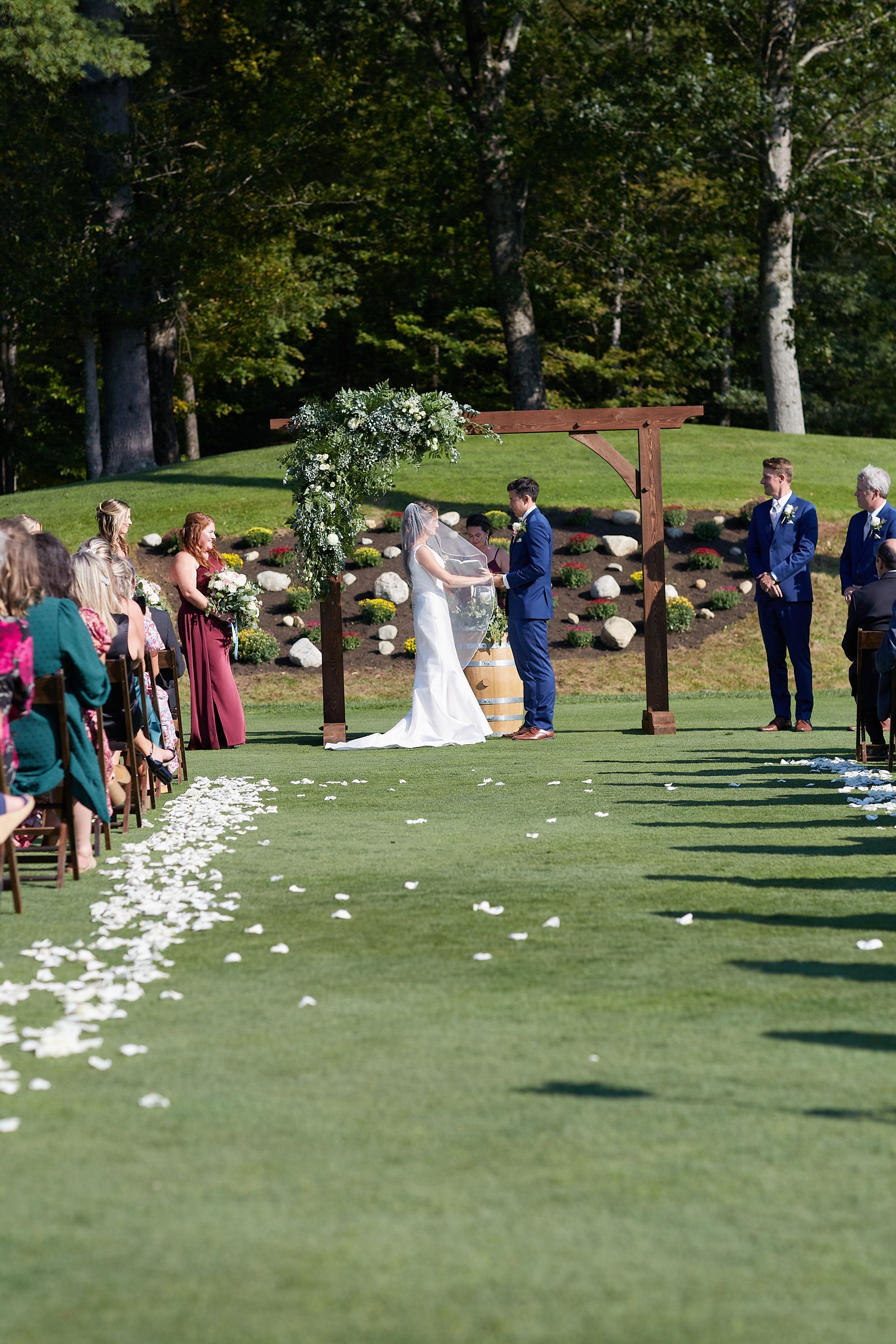 A bride and groom are getting married in front of their wedding guests.