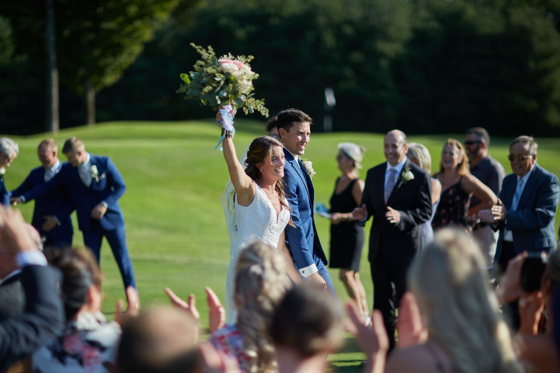 A bride and groom are walking down the aisle at their wedding.