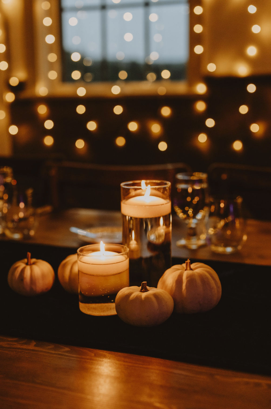 There are pumpkins and candles on the table.