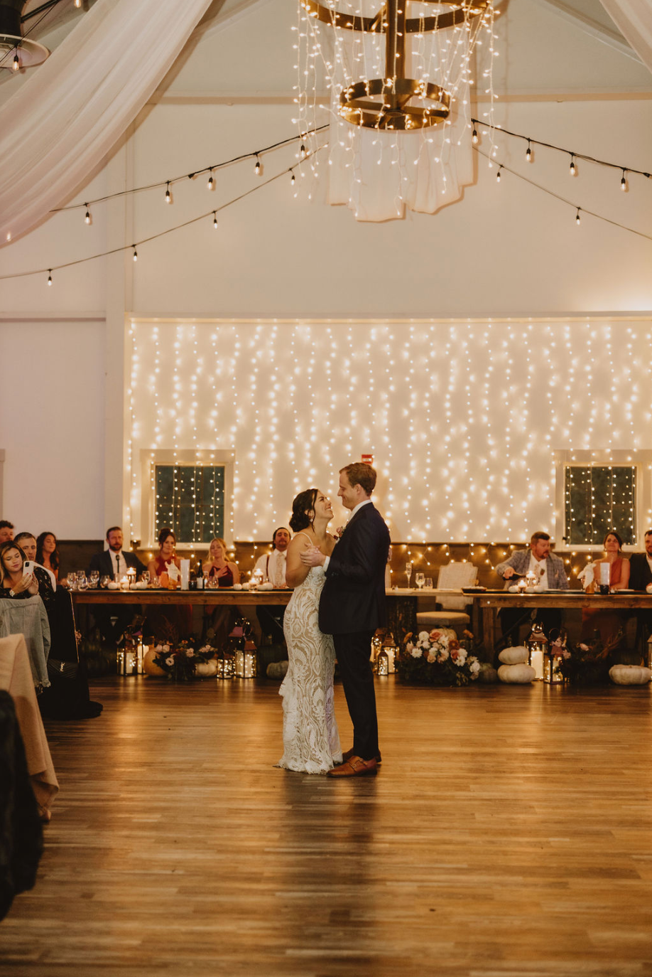 A bride and groom are dancing their first dance at their wedding reception.