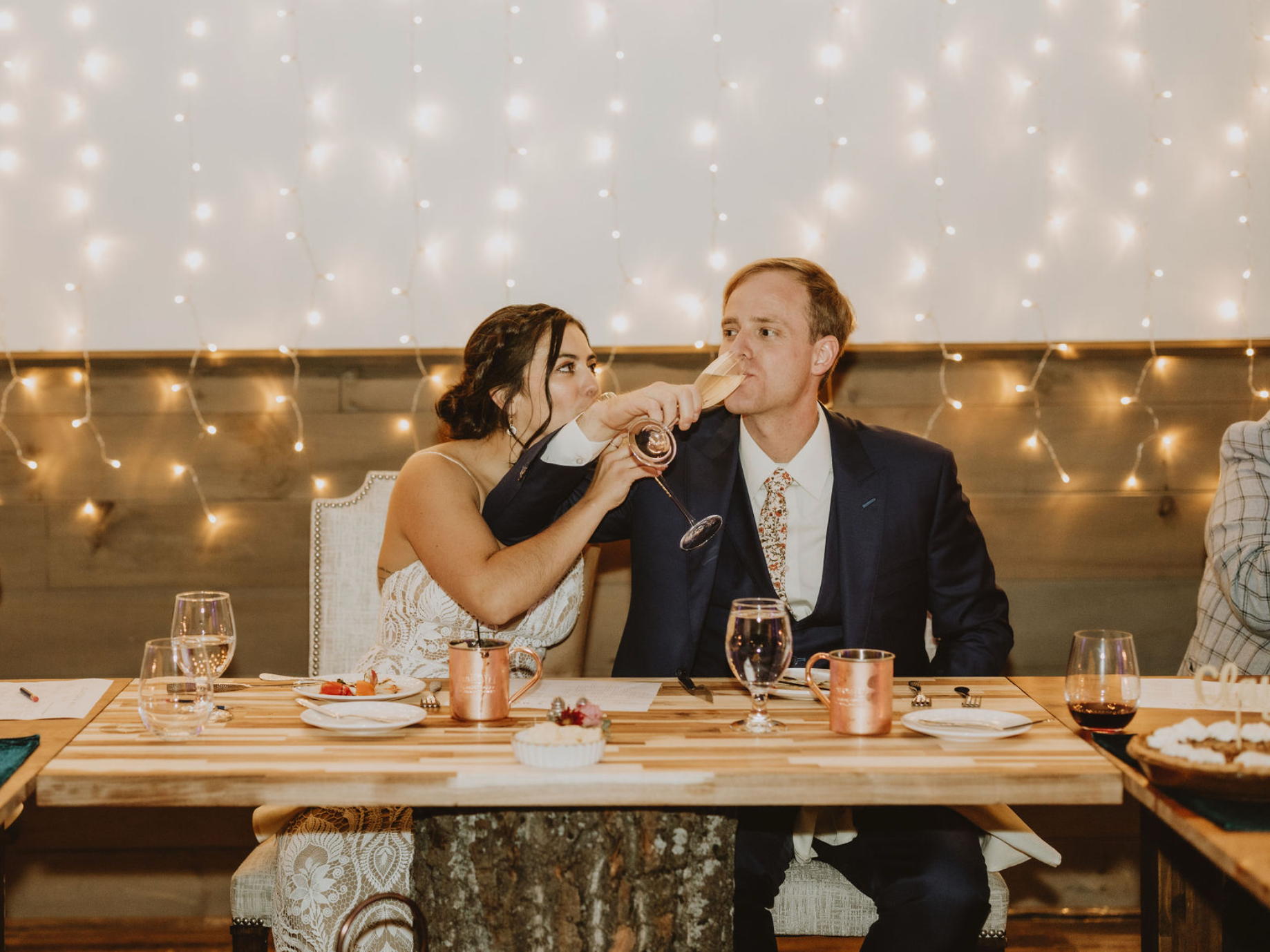 A bride and groom are toasting with champagne at their wedding reception.