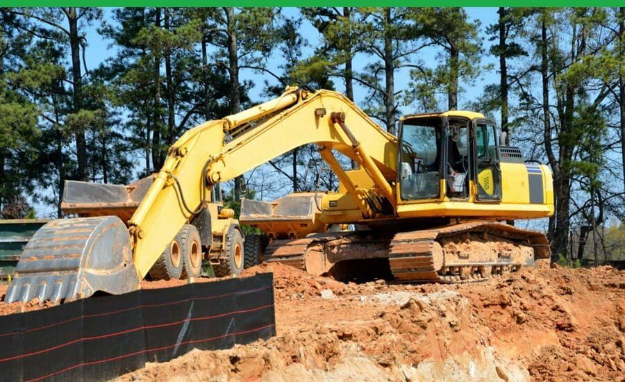 A yellow excavator is moving dirt on a construction site.