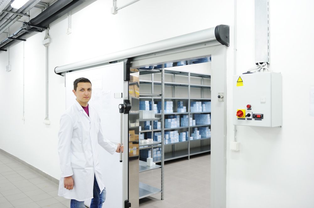 A Man In A Lab Coat Is Opening A Sliding Door In A Storage — EasyLock Storage In Southport, QLD