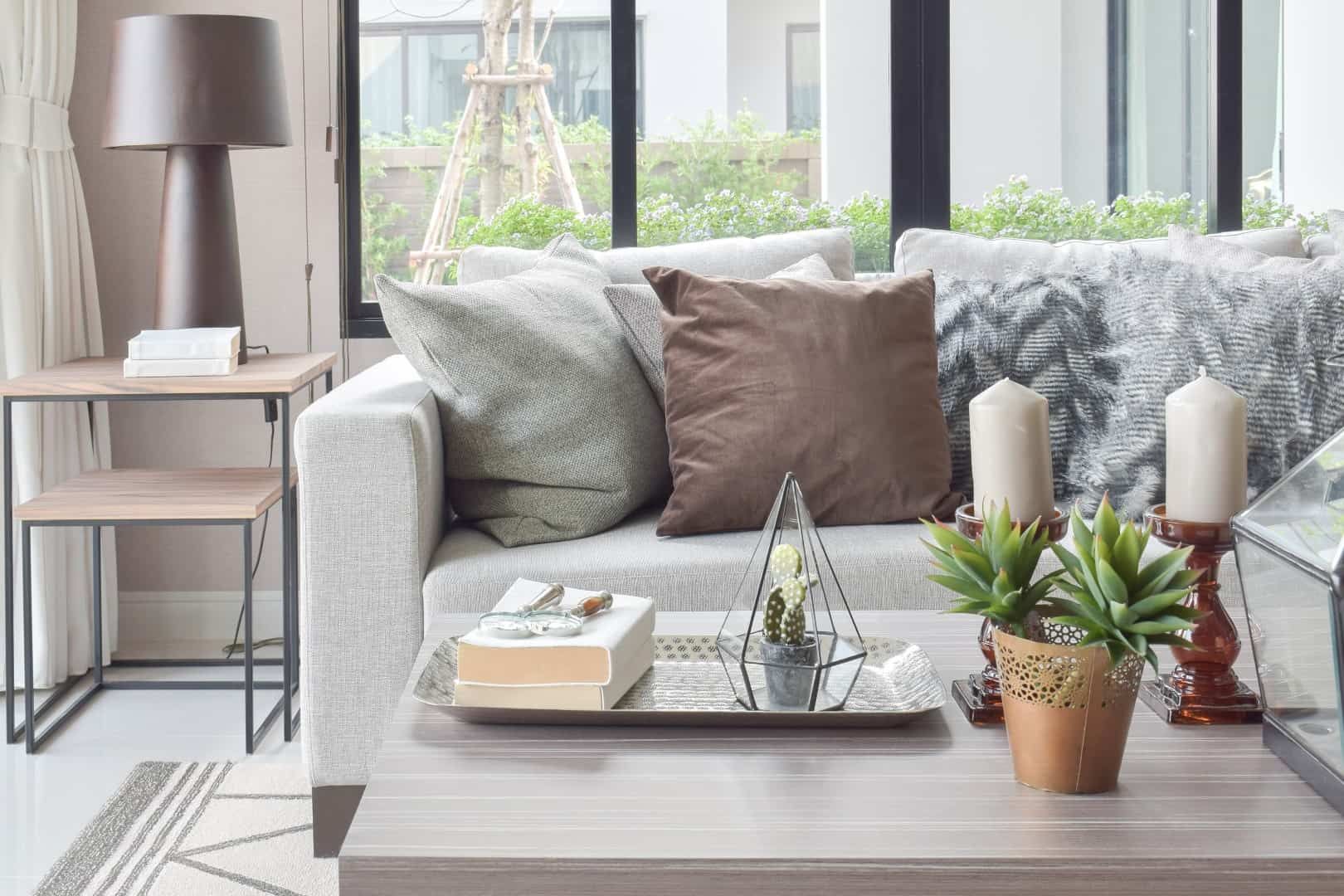 Brown,And,Texture,Pillows,On,Beige,Sofa,With,Candles,On