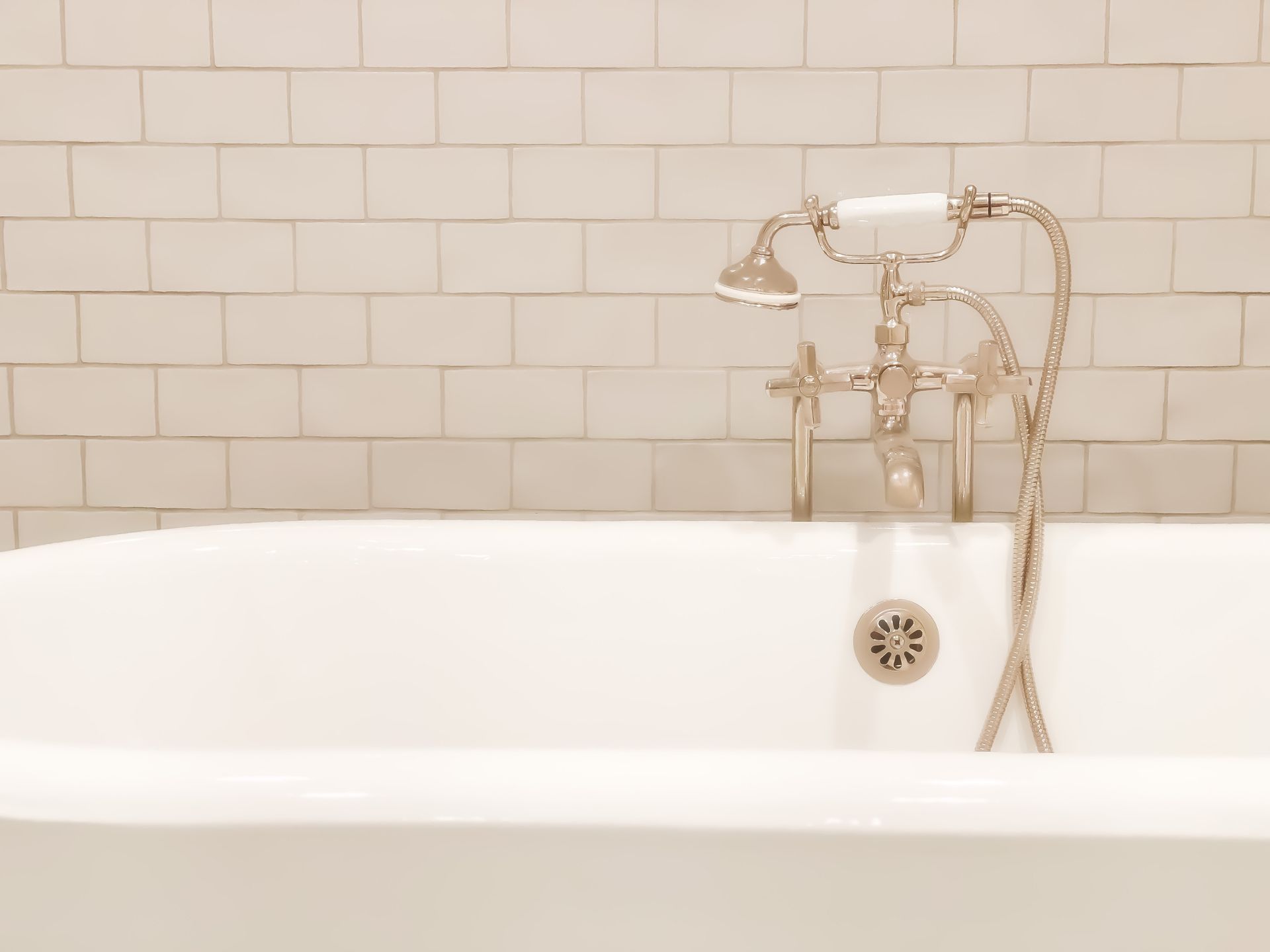 White vintage bathtub with faucet and tiles.