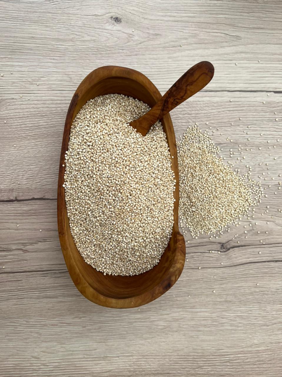 Quinoa in a wooden bowl with wooden spoon