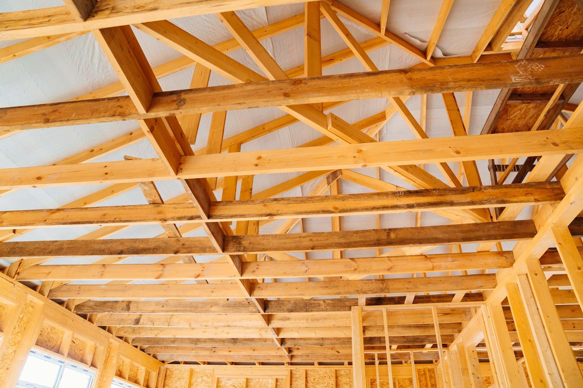 Wooden framework of a building's roof and interior walls during the construction process.