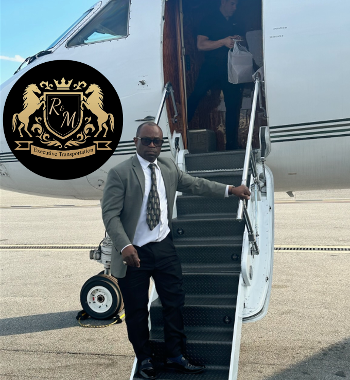 A man in a suit and tie is standing in front of a rm airplane