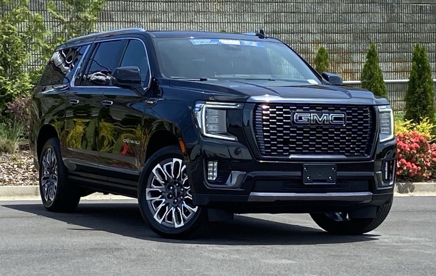 A black gmc yukon suv is parked in a parking lot.