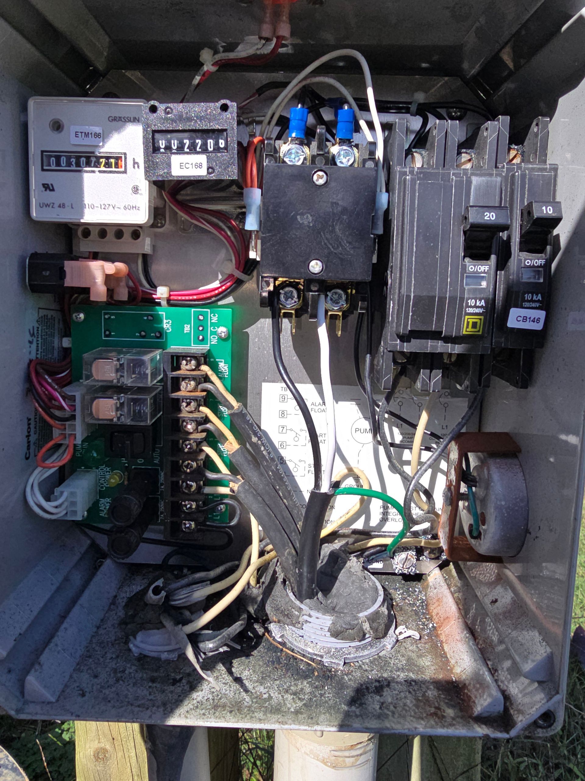 Open electrical box with various components and wiring.