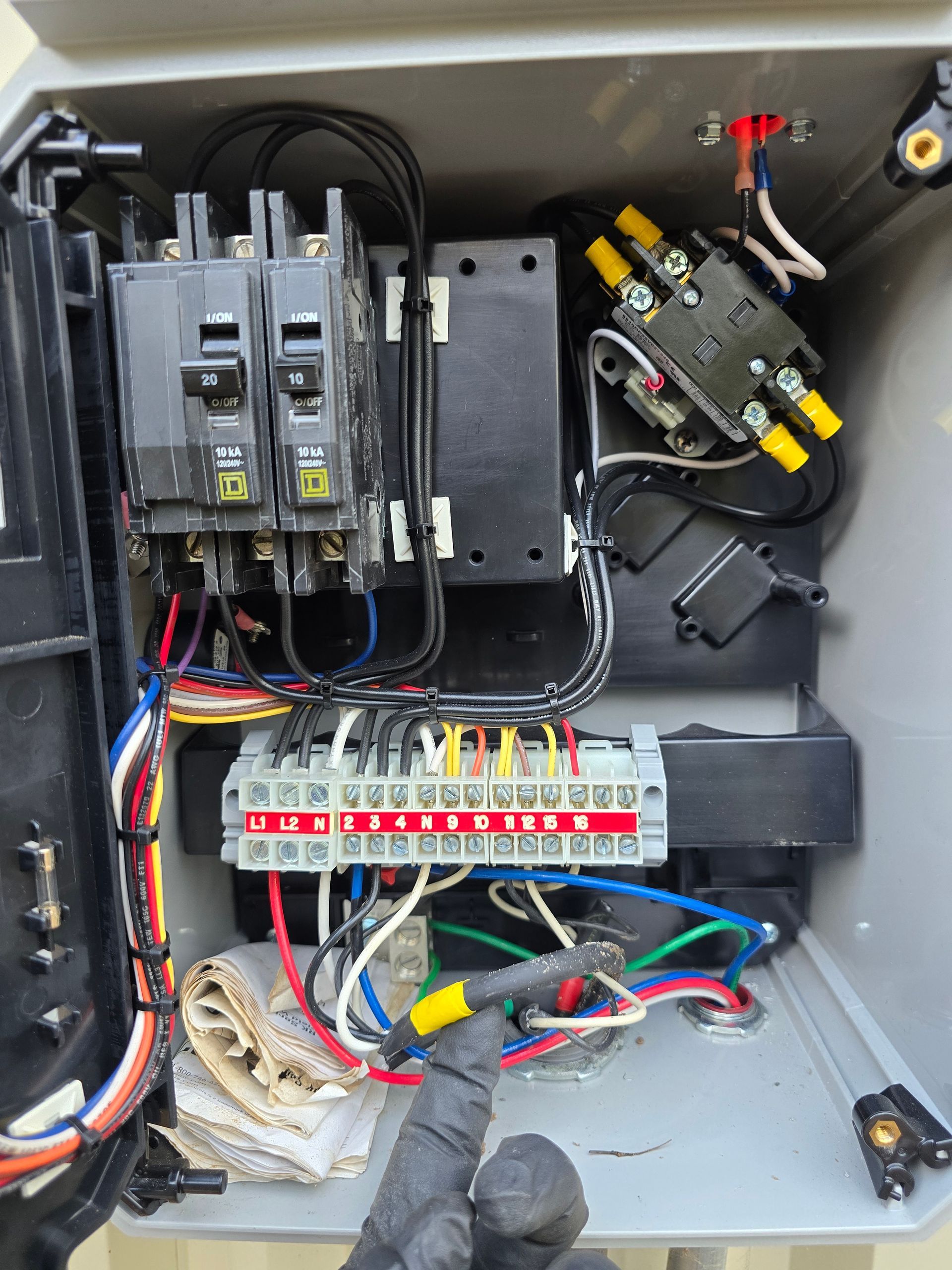 Electrical control box with circuit breakers, wiring terminals, and a black box.