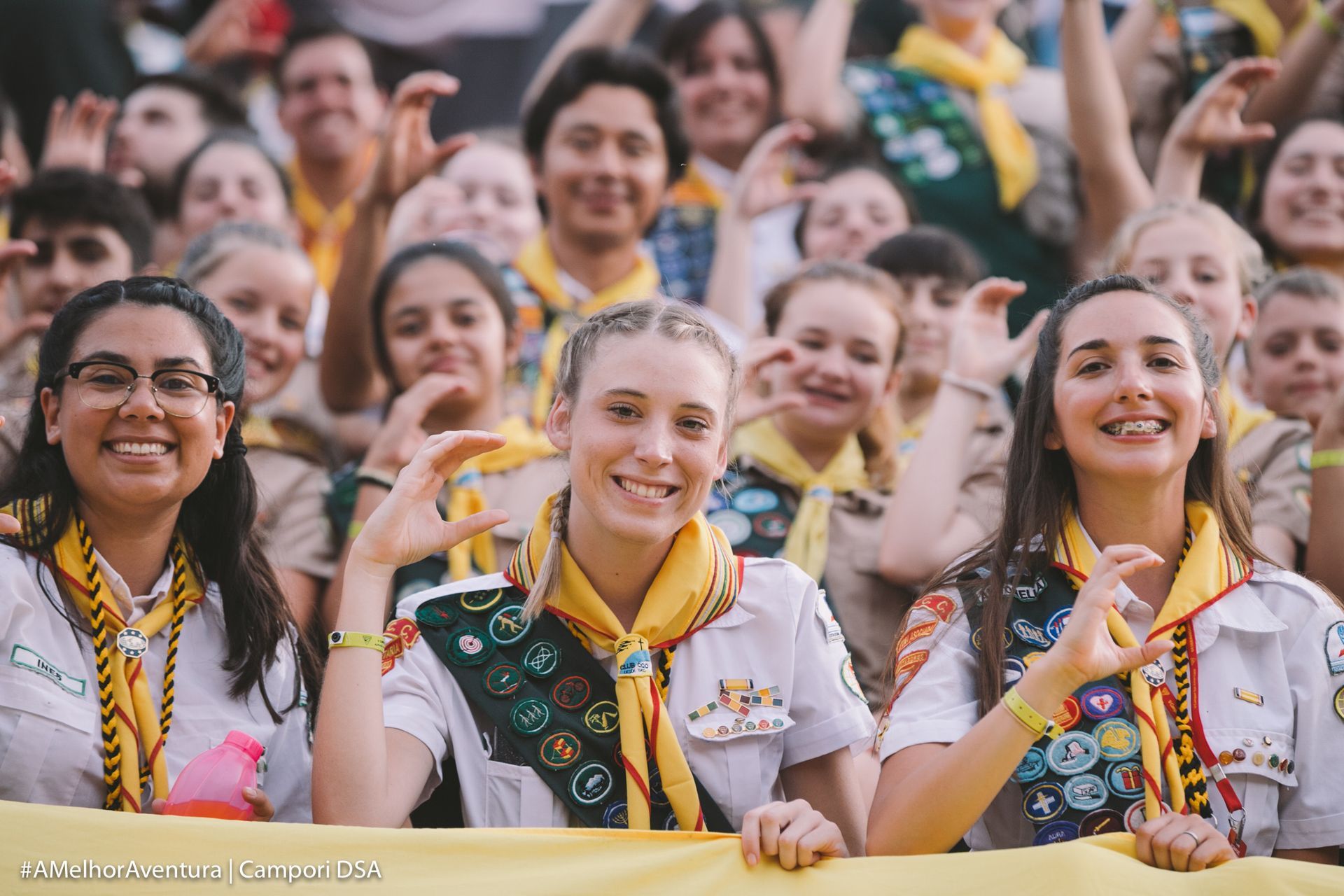 A group of Adventist youth pathfinder posing for a picture in front of a crowd.