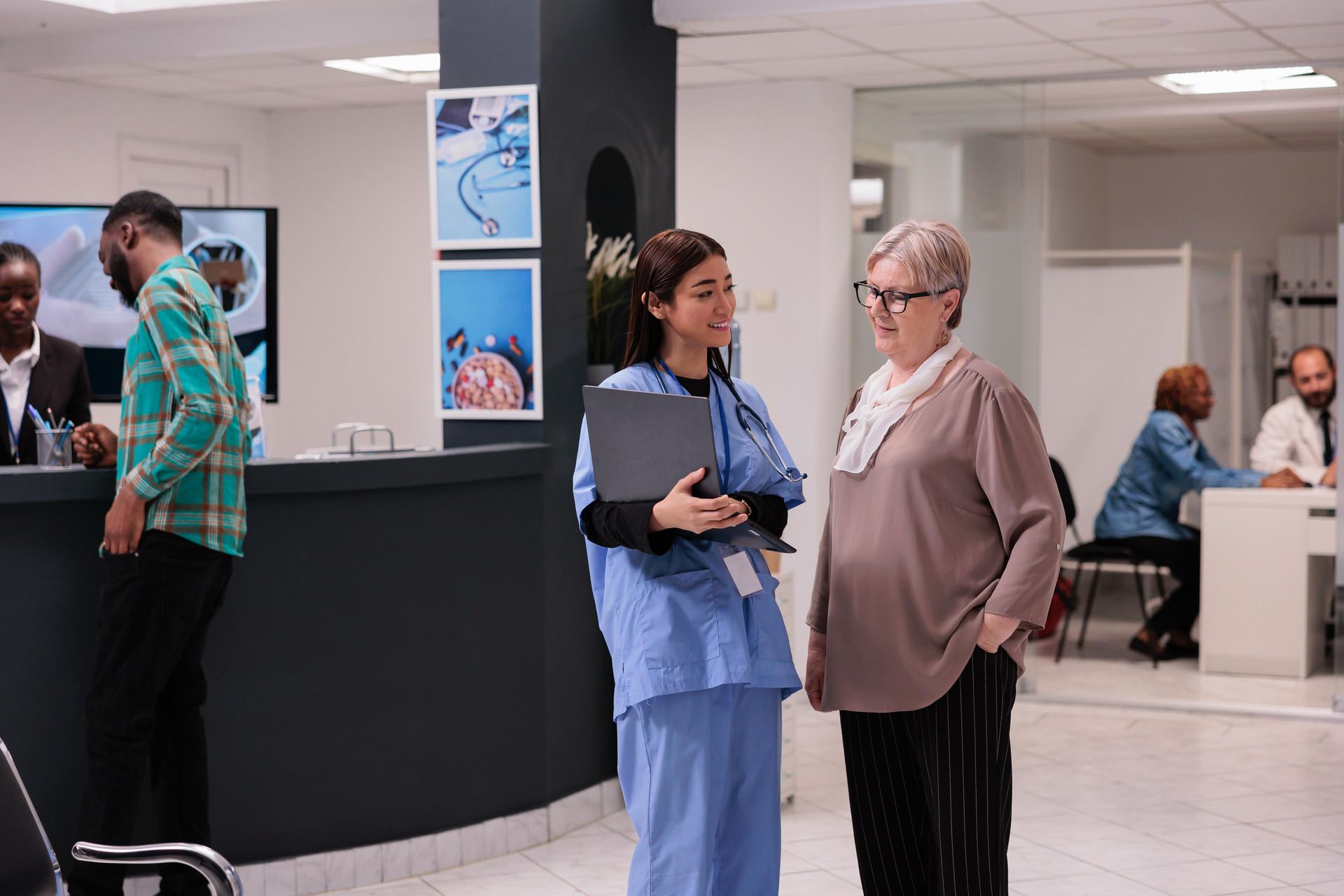A nurse is talking to a patient in a hospital lobby.
