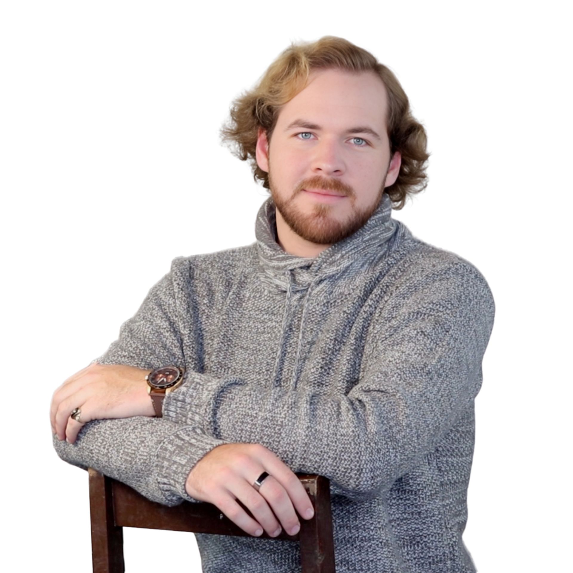 A man in a grey sweater is leaning on a chair